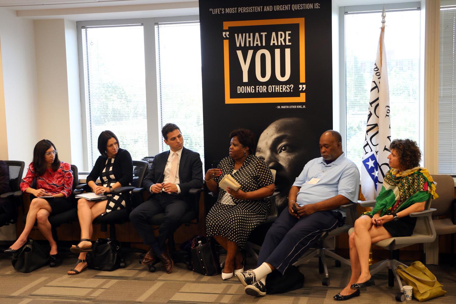 Six people sit around an MLK Day of Service event banner