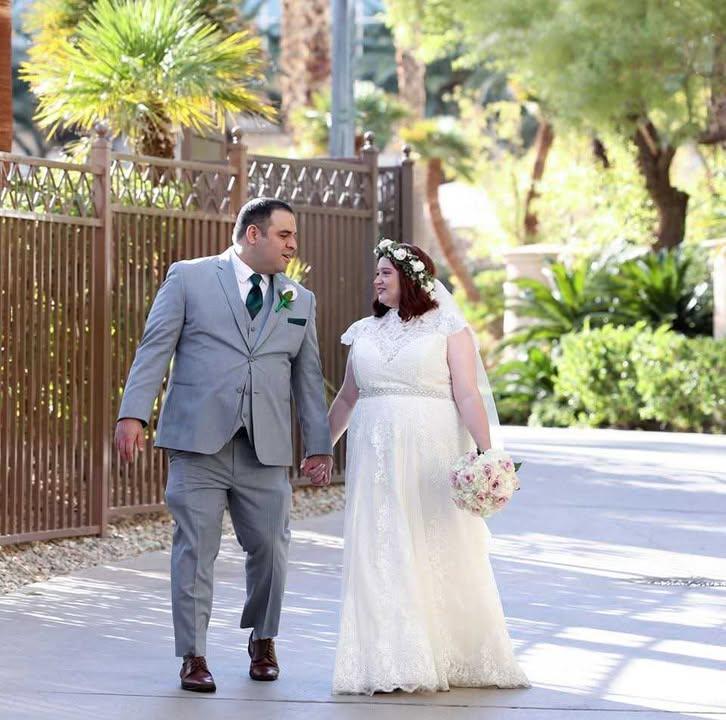 A couple on their wedding day in a wedding dress and grey tuxedo