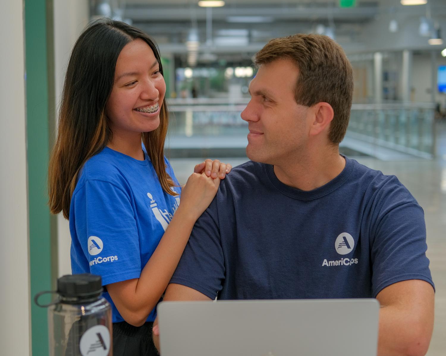 Two AmeriCorps members smiling at each other 