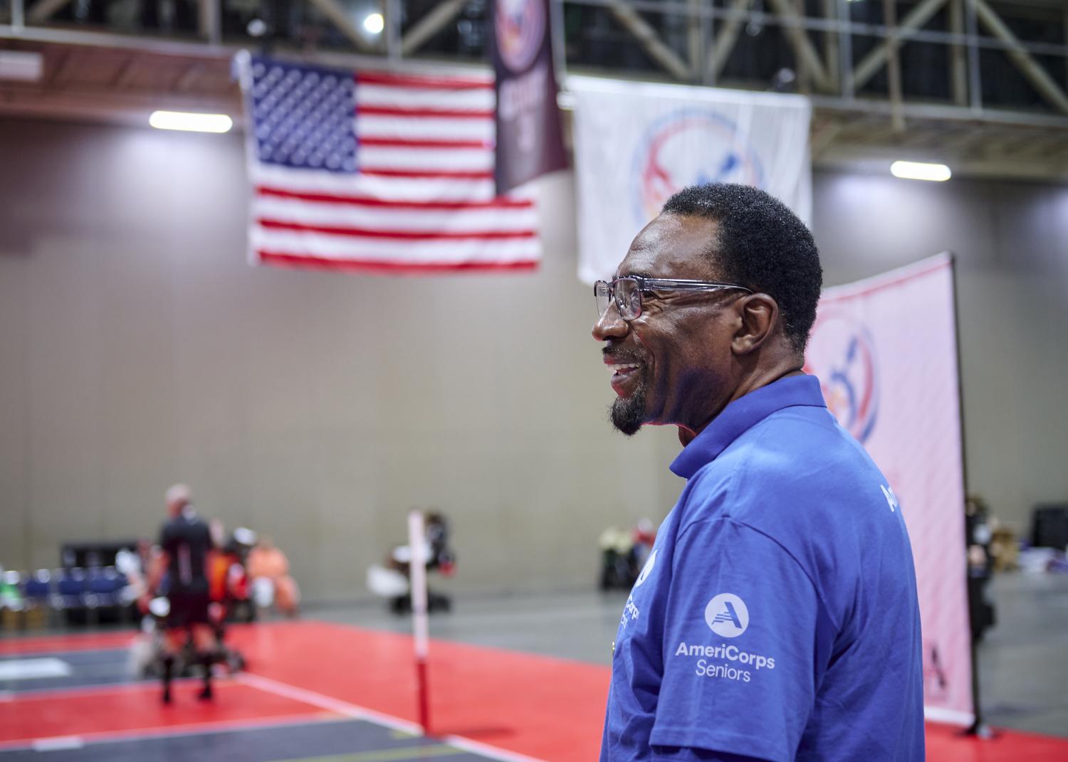 An AmeriCorps Seniors volunteer in front of an American flag