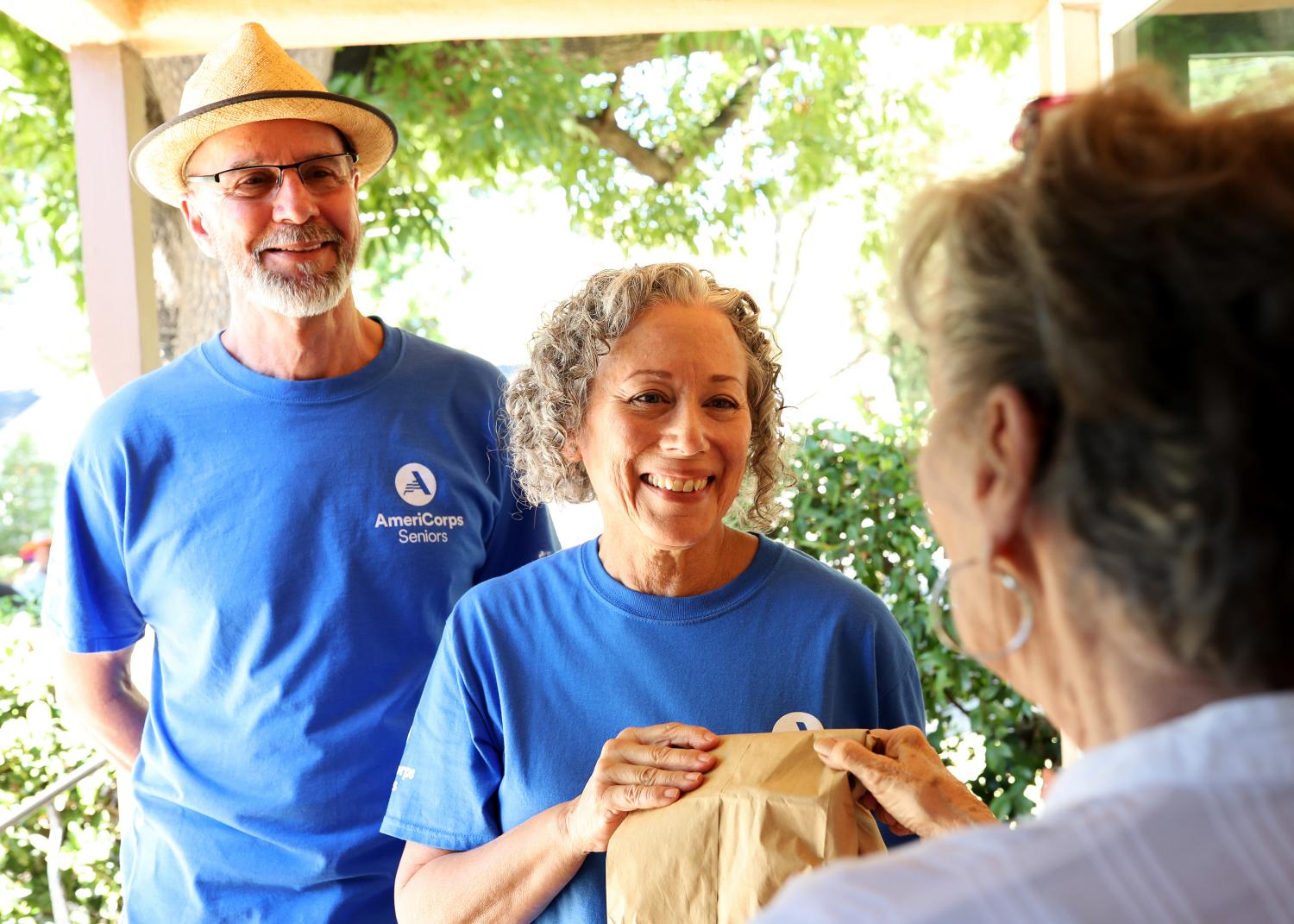 AmeriCorps Seniors volunteers deliver meals to another older American.