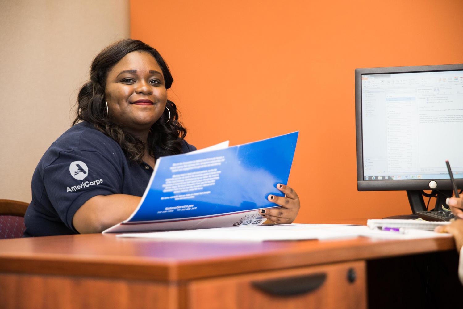 AmeriCorps member serving with VISTA works at a desk.