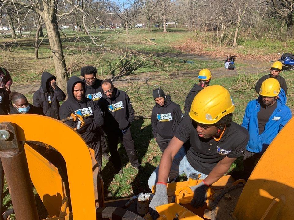 Jaiden demonstrating the use of a wood chipper to a new crew